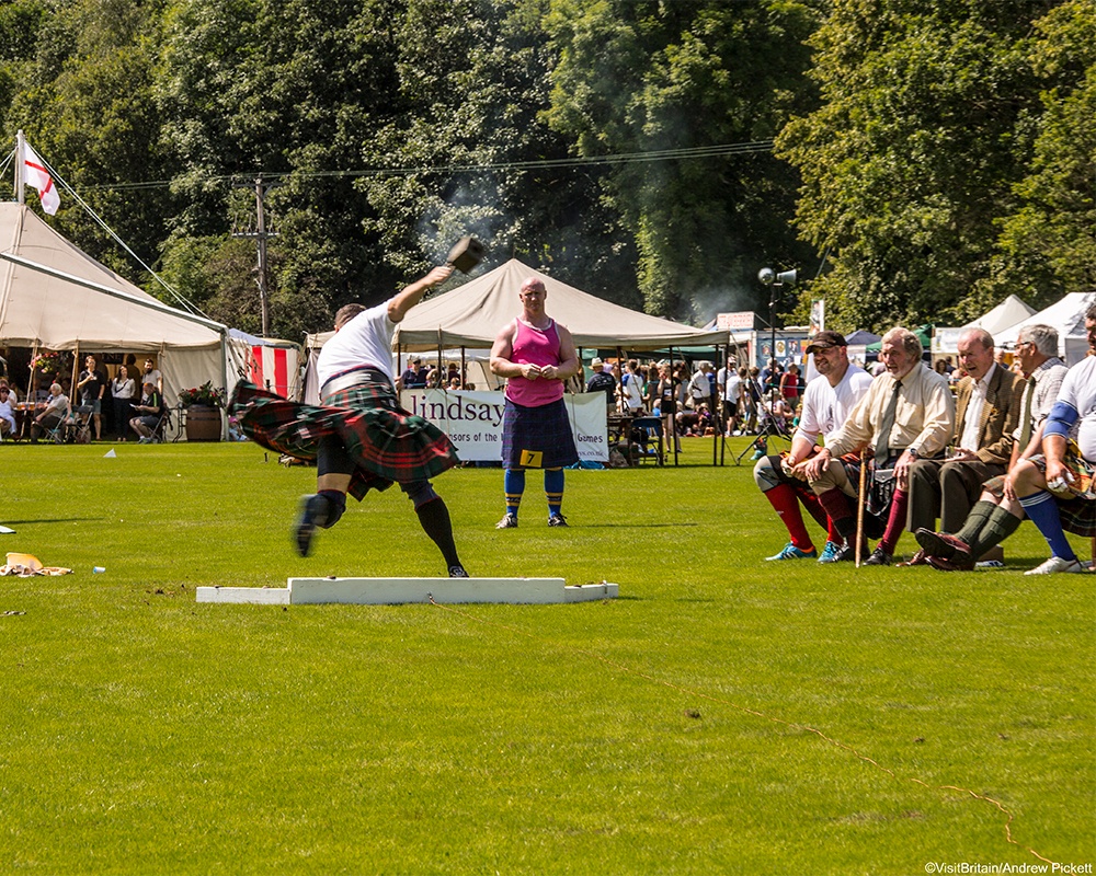 Image of man wearing kilt throwing a weight at Inverary Highland Games, Inverary Castle, Scotland. Photo by Andrew Pickett/VisitBritain.