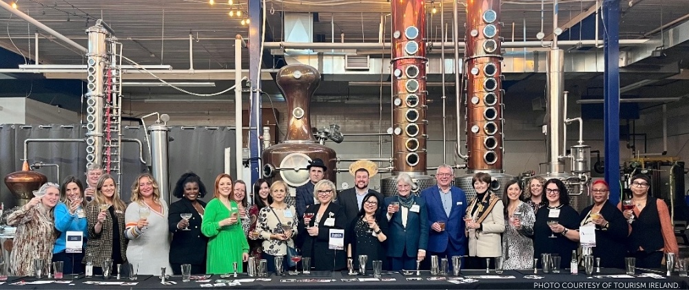 Tourism Ireland's Business Events Showcase at Reid's Distillery in Toronto, Ontario, Canada, on November 15, 2023. This image shows the attendees at the event with the distillery's machinery behind them. Image courtesy of Tourism Ireland.