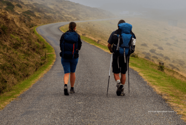 This is an image of two pilgrims walking the Camino de Santiago in the French Pyrenees. Photo by bepslabor | Canva.