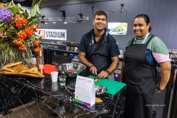 This image shows two exhibitors in the National Indigenous Culinary Institute's booth at AIME 2023 in Melbourne, Australia. Photo is courtesy of Melbourne Convention Bureau.