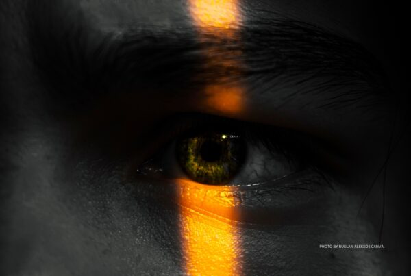 This image shows a human eye with a bar of light running down the middle. Photo by Ruslan Alekso | Canva.
