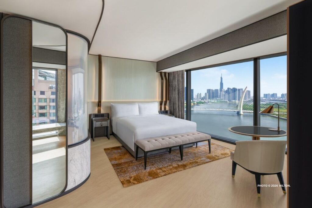 This is an image of a King Deluxe Corner Suite with river view at Hilton Saigon, which opened in March 2024. Photo © 2024 Hilton.