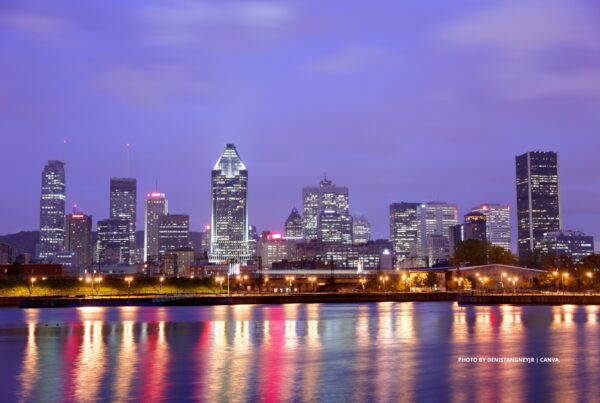 This is a stock image of the Montreal skyline at night with the St. Lawrence River in the foreground. Photo by DanisTangneyJr | Canva.