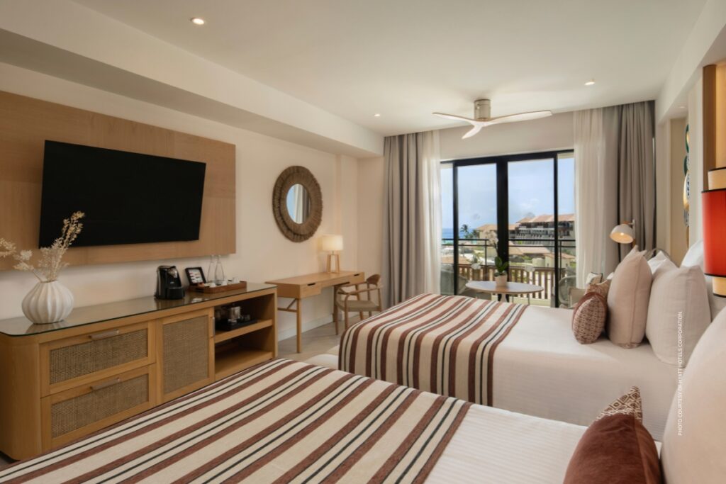 This image shows the interior of bedroom in a Junior Suite with a partial oceanview at Dreams Playa Esmeralda Resort & Spa in the Dominican Republic. Photo courtesy of Hyatt Hotels Corporation.
