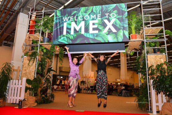 IMEX in Frankfurt returned to the world stage this year . Image here shows two exhibitors jumping up under Welcome to IMEX sign. Photo courtesy of IMEX Group.
