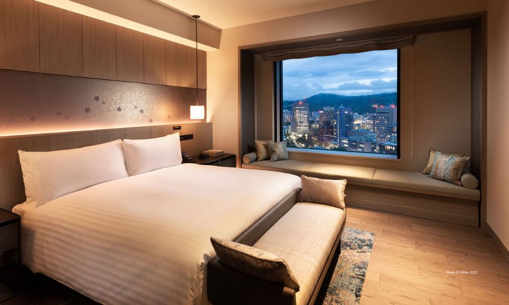 Hilton Hiroshima opened in fall 2022. This is an image of the bedroom in a suite at Hilton Hiroshima. Photo © HIlton 2022.