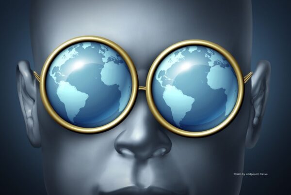 Study looks at global state of incentive travel industry. This is a stock image of a person's head wearing round glass frames with world globes as lenses. Photo by wildpixel | Canva.