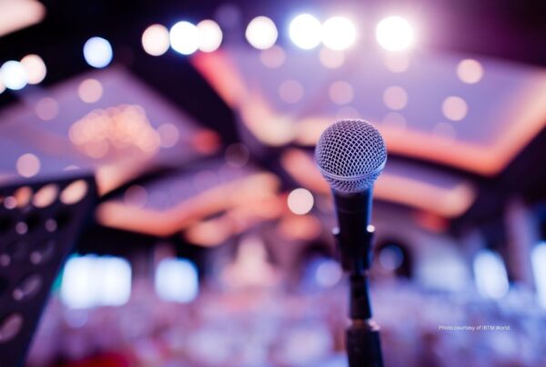 Salesforce event lead announced as first keynote speaker for IBTM World 2022. This image shows a microphone on a stage with the conference hall blurred. Photo by varunyu suriyachan | Canva.