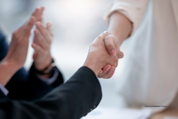 IME Connect of Parsippany, New Jersey was acquired by M-Plus Global Events in November 2022. This image is a stock photo of two people shaking hands with a third person clapping in the background. Photo is by Nathaphat | Canva.