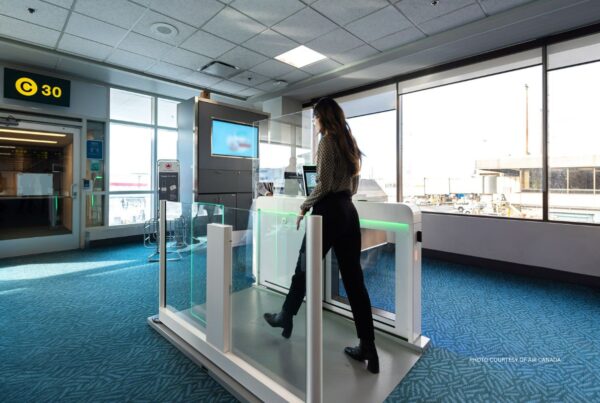 Digital identification is currently be tested by Air Canada. This image shows a woman walking through a scanner at an airport boarding gate. Photo is courtesy of Air Canada.