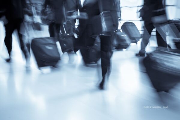 Live events will drive the recovery of business travel in 2023 according to a new study by Deloitte. This image is a stock photo of business travelers racing through airport. Photo by ymgerman | Canva.