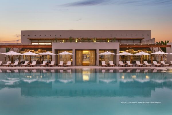 This image is a rendering of the pool and lounge chairs and building at The Legend Paracas Resort in Peru, which will join Hyatt's Destination by Hyatt brand in June 2024. Image courtesy of Hyatt Hotels Corporation.