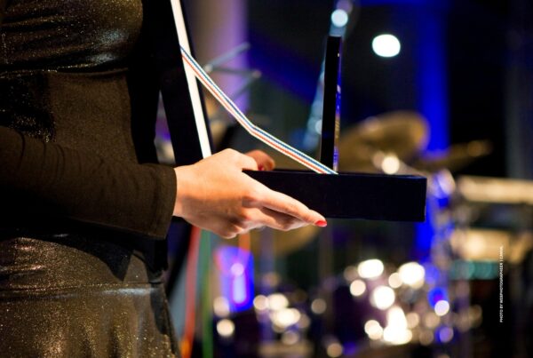 This is a stock photo of a woman either giving or accepting an award. Photo by webphotographeer | Canva.