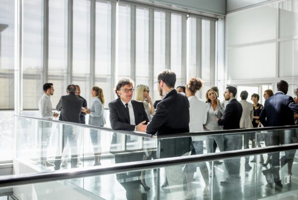 This is a stock photo of attendees at a business event talking to one another at a networking event . Photo by sanjeri | Canva.