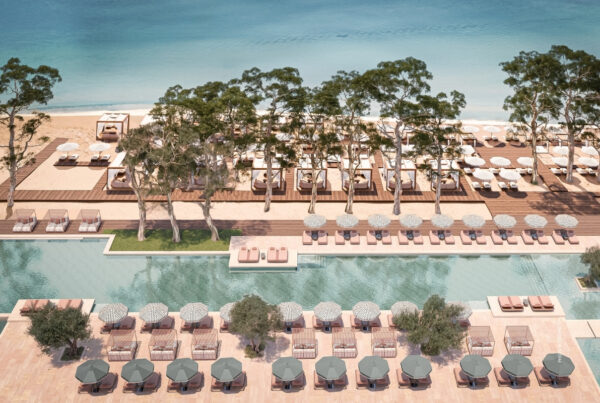 This is an aerial image of an outdoor pool and lounge chairs at Conrad Corfu with Ionian Sea in the background. Photo © 2025 Hilton.
