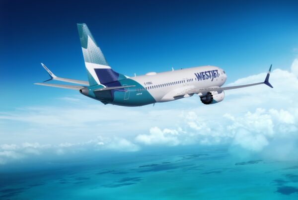 This is an image of a WestJet Boeing 737 Max flying over islands in the Caribbean on a clear day. Photo courtesy of WestJet.